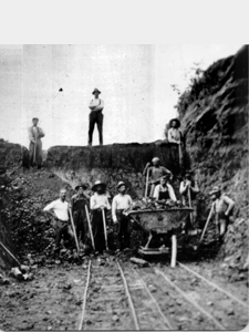 The men shown building what is now 240th Street had to cut down the height of the hills by shoveling out a notch for the road to travel through.