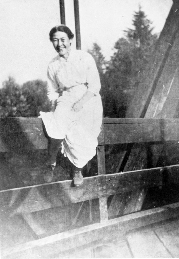 Susan Greenwell sitting on bridge over Alouette River in about 1915